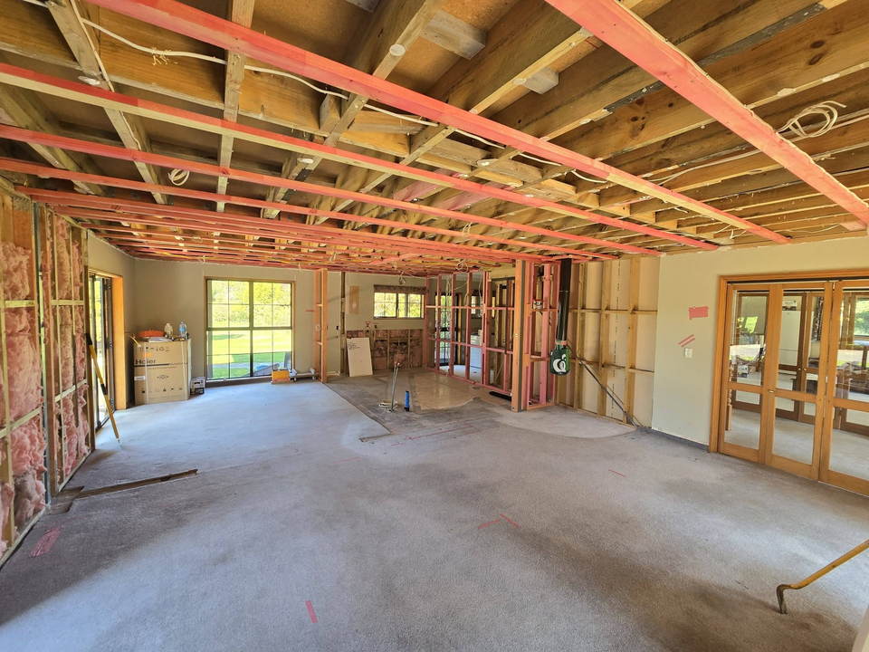 During: the living area stripped back to timber framing, with new ceiling battens and the walls open