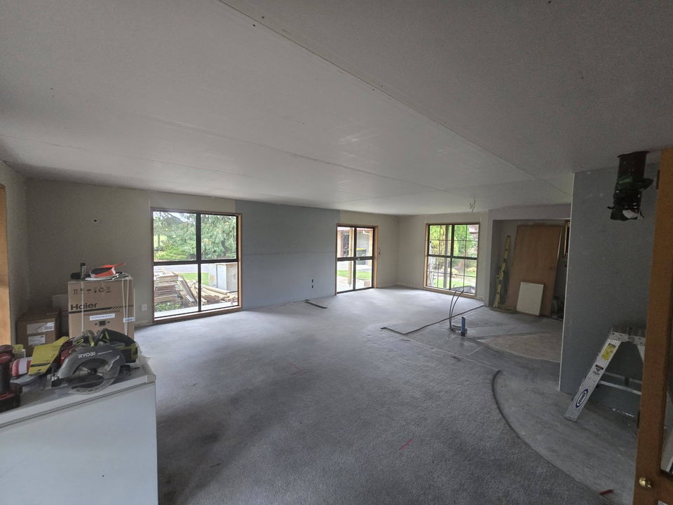 Living area after relining: new plasterboard on the walls and ceiling, joints stopped, windows and French doors in place