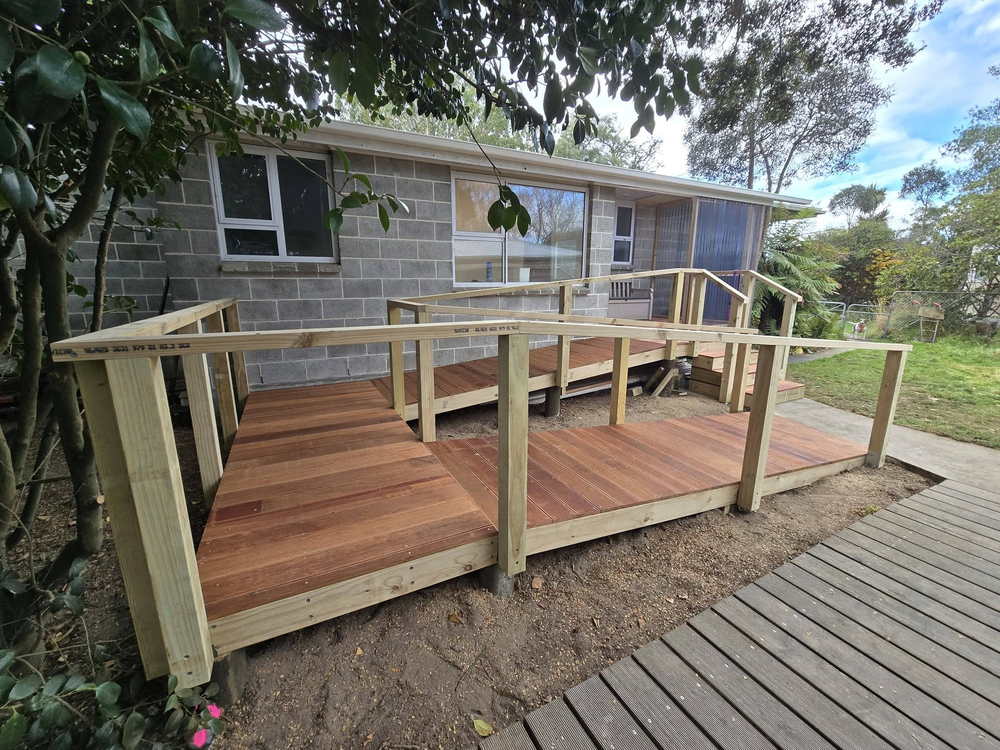New timber deck with a post-and-rail balustrade against a block wall
